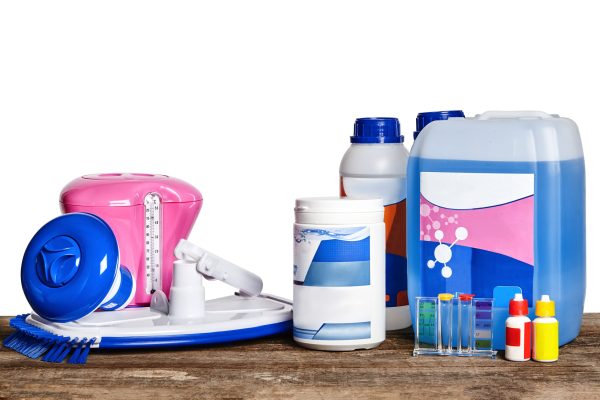 Quality equipment with chemical cleaning products and tools for the maintenance of the swimming pool on a wooden surface against a white background. Disinfectant, detergent, cleanser. Close-up front view.